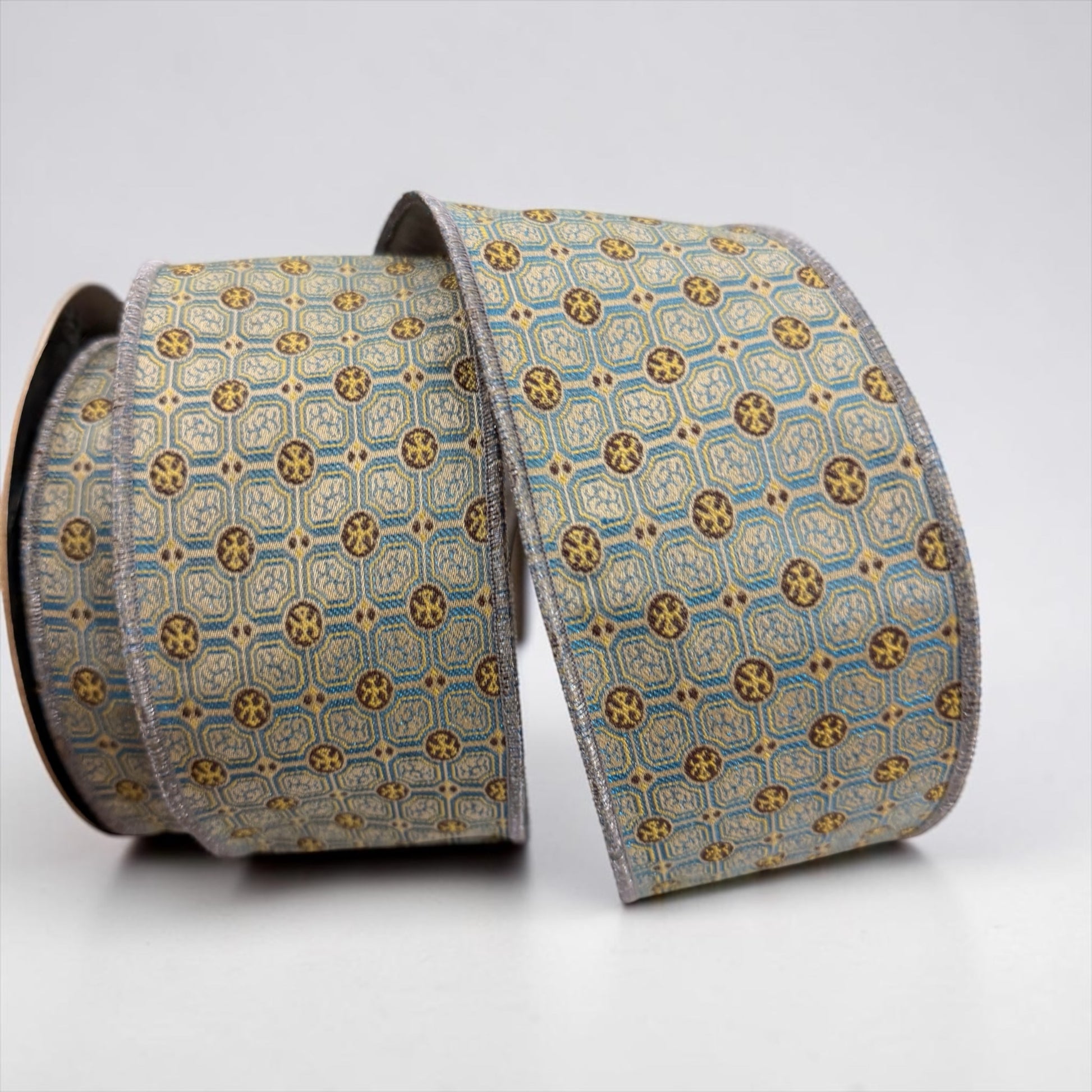 D. Stevens 2.5 inch Jacquard Cravat Blade wired designer ribbon with geometric blue, brown, beige and gold-toned medallion pattern and grey backing on a 10-yard roll.