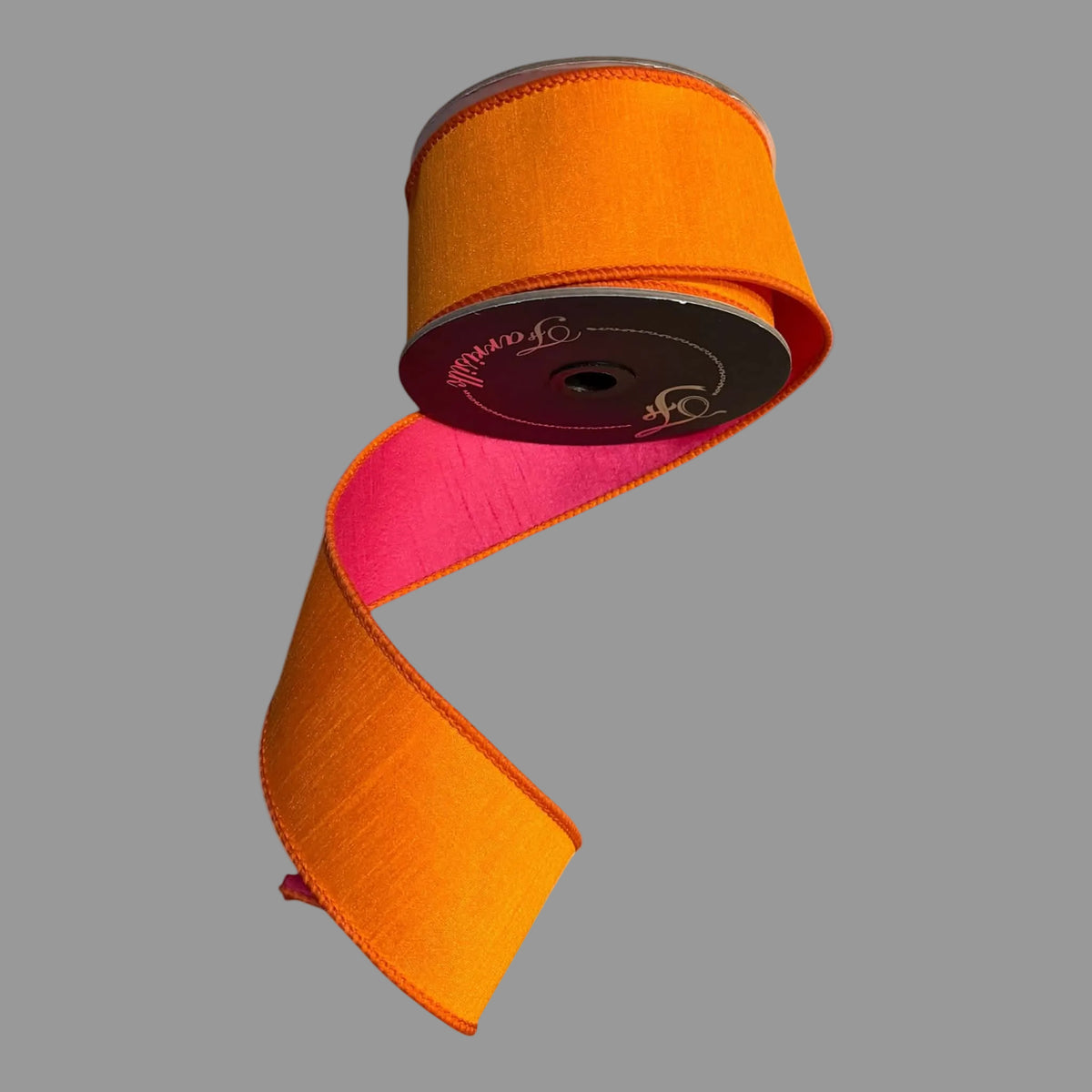 Farrisilk 2.5-inch x 10-yard two-tone dupioni designer ribbon on a black spool, featuring a rich orange face with coordinating stitched edges and a vivid hot pink reverse visible on the loose tail.