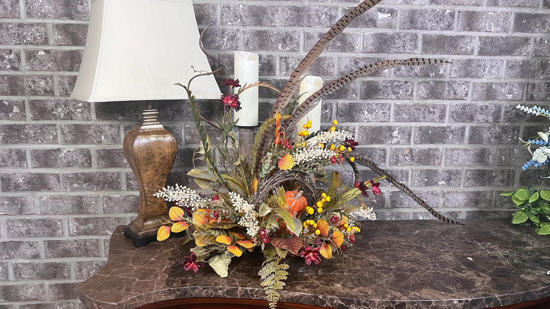 Eclectic “One of a Kind” Fall Grapevine Stand arrangement. Fuzzy Orange Jute wrapped stem pumpkins with golden berries with Pheasant Feather