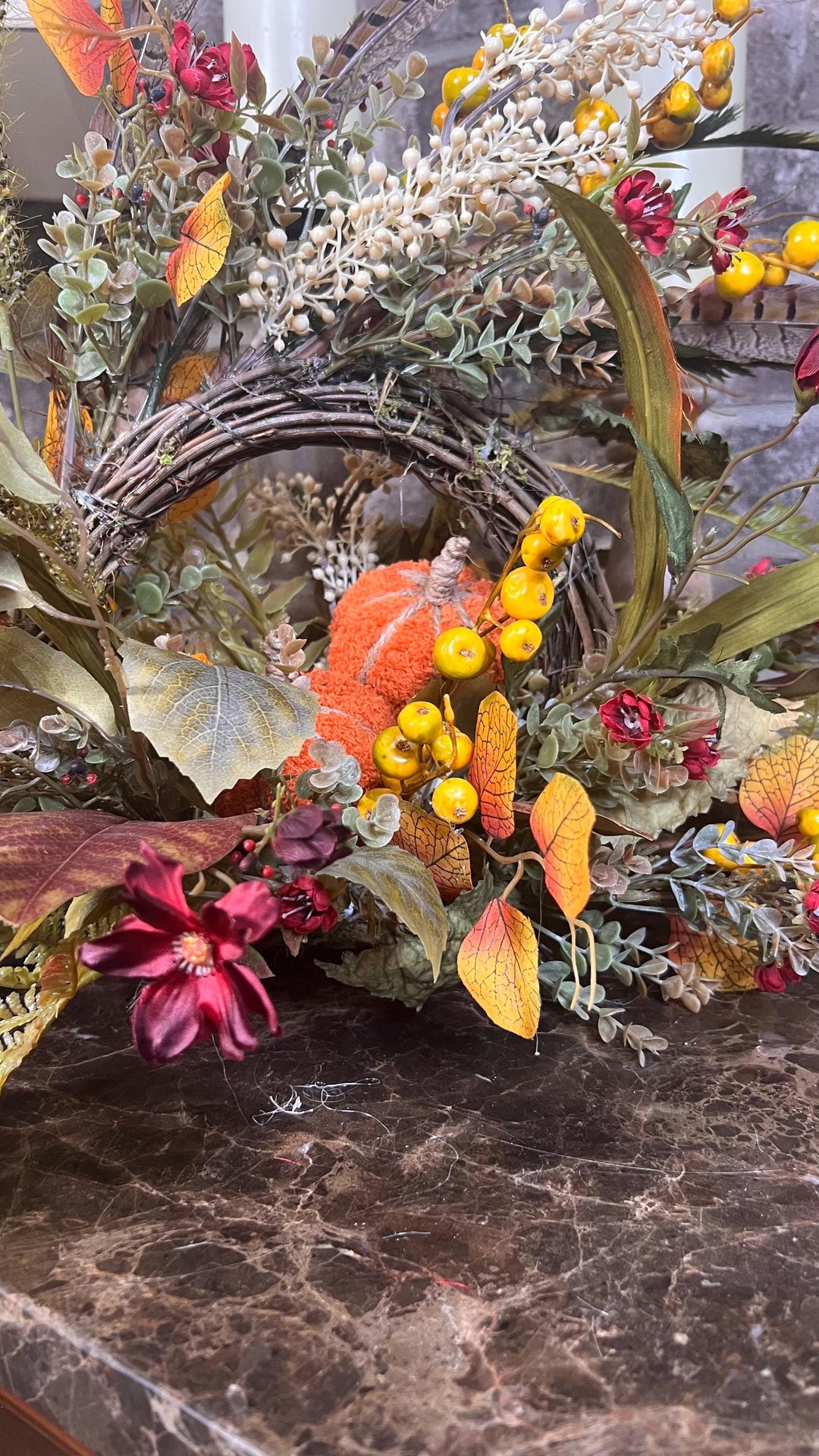 Eclectic “One of a Kind” Fall Grapevine Stand arrangement. Fuzzy Orange Jute wrapped stem pumpkins with golden berries with Pheasant Feather