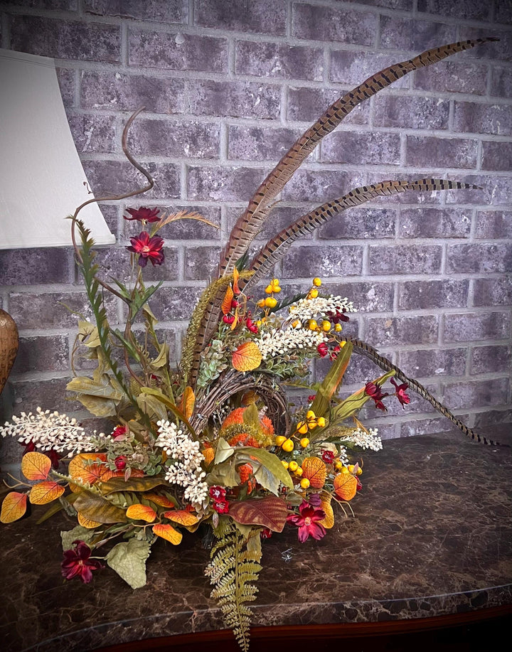 Eclectic “One of a Kind” Fall Grapevine Stand arrangement. Fuzzy Orange Jute wrapped stem pumpkins with golden berries with Pheasant Feather