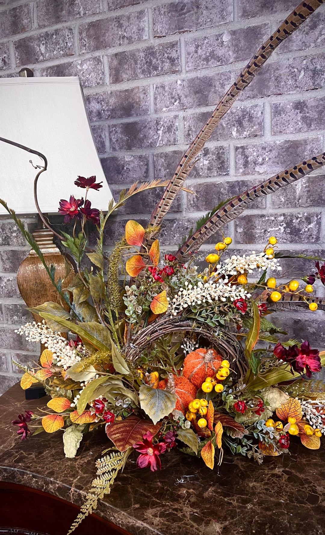 Eclectic “One of a Kind” Fall Grapevine Stand arrangement. Fuzzy Orange Jute wrapped stem pumpkins with golden berries with Pheasant Feather