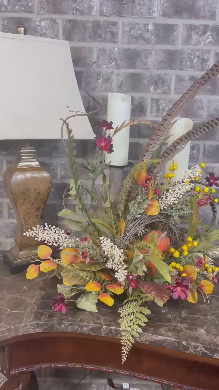 Eclectic “One of a Kind” Fall Grapevine Stand arrangement. Fuzzy Orange Jute wrapped stem pumpkins with golden berries with Pheasant Feather